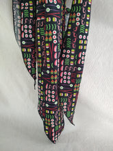 Load image into Gallery viewer, A display of various neck coolers made from different fabrics, tied in a knot, hanging.