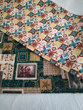 Load image into Gallery viewer, A reversible table runner with a Christmas-themed pattern featuring a variety of holiday motifs such as stars and Christmas trees, primarily in red, blue, and yellow hues, with metallic gold accents.