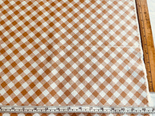 Load image into Gallery viewer, A close-up of a gingham fabric with a brown and white checkered pattern, shown with a wooden ruler on the right and a metal ruler on the bottom to indicate scale.
