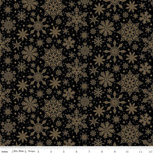 Load image into Gallery viewer, Black fabric with a repeating pattern of gold snowflakes and small gold dots, shown flat with a ruler along the bottom edge.
