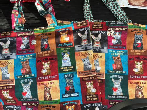 Collection of colorful coffee-themed totes with cat illustrations.